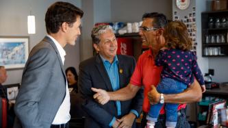 PM Trudeau and MP Vandal speak with a man and his daughter