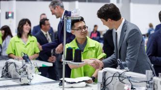 PM Trudeau shakes hands with a factory worker
