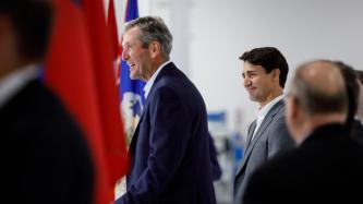 Premier Pallister speaks while PM Trudeau looks on