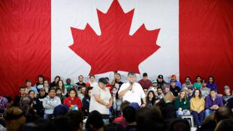 A man in the audience talks using the microphone