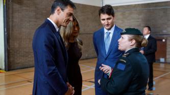 President Sánchez, his wife, and PM Trudeau listen to a military personnel