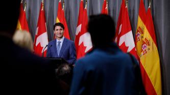 PM Trudeau listens to a reporter