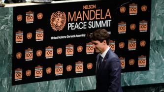 PM Trudeau in front of a sign that reads: Nelson Mandela Peace Summit