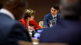 PM Trudeau listens to a fellow delegate