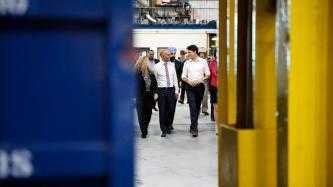 Le PM Trudeau marche en parlant avec un homme et une femme