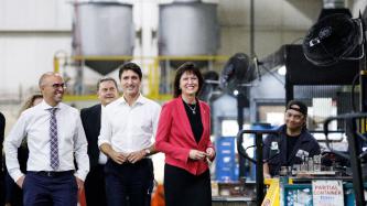 Le PM Trudeau se fait prendre en photo avec des gens dans l'usine