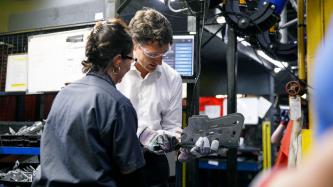 Une ouvrière démontre l'utilisation d'une machine au PM Trudeau