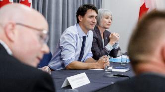 Le PM Trudeau et la ministre Hajdu écoutent lors d'une rencontre
