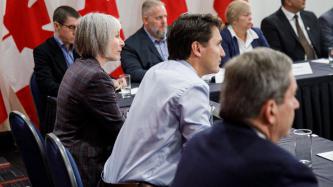 Le PM Trudeau et la ministre Hajdu écoutent lors d'une rencontre