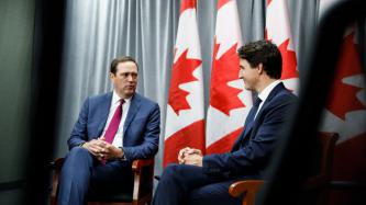 PM Trudeau sits and listens to CEO Chuck Robbins