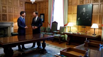 PMs Trudeau and Rutte stand and talk in the Speaker's Office
