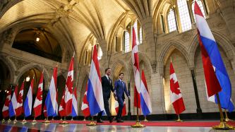 PM Trudeau and PM Rutte walk down the Hall of Honour