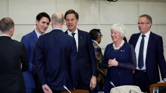 PM Trudeau and PM Rutte speak with a man