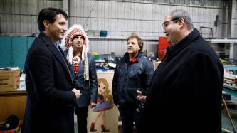 PM Trudeau, Mayor Spence and Grand Chief Dumas speak with a man