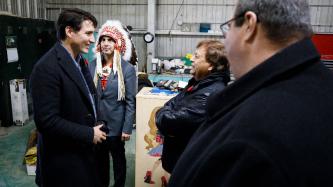 PM Trudeau speaks with Mayor Spence while others look on
