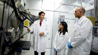 PM Trudeau speaks with a man and woman in a lab coat