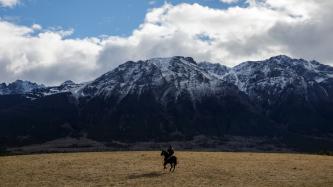 Le PM Trudeau se promène dans une vallée sur un cheval noir