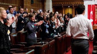 The attendees stand and applaud PM Trudeau