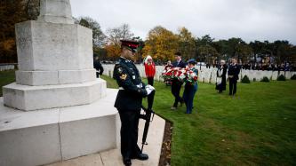 Le PM Trudeau et un militaire déposent des fleurs sur un monument