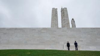 PM Trudeau and Minister O'Regan stand beside the monument