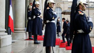 PM Trudeau enters the Élysée Palace while guards stand at attention  