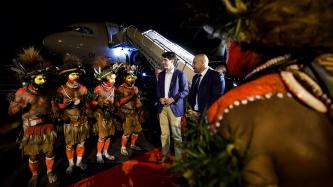 Papuan men in traditional clothing greet PM Trudeau