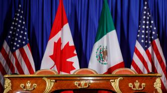 A table in front of flags of Canada, United States and Mexico