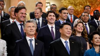 World leaders and their spouses smile for a group photo