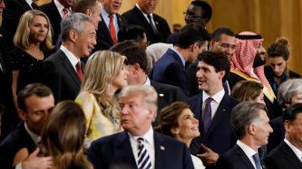 PM Trudeau speaks with others during a group photo