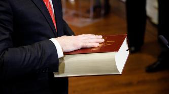 Le ministre Lametti dépose sa main sur une bible