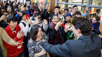 PM Trudeau smiles as students take photos