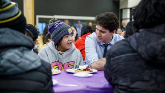 PM Trudeau sits and talks with a group of students