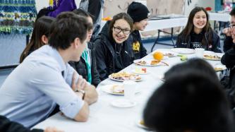 PM Trudeau sits and talks with a group of students