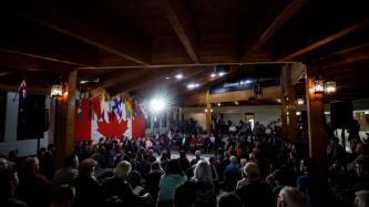 PM Trudeau holds a microphone and speaks to the crowd