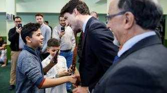 PM Trudeau shakes hands with a boy
