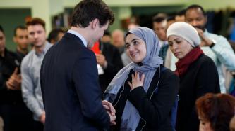 PM Trudeau shakes hands with a woman