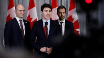PM Trudeau speaks while MP Duclos and MP Lightbound look on