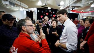 PM Trudeau listens to a man speak