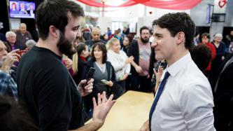 PM Trudeau listens to a man speak