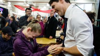 PM Trudeau shakes hands with a woman