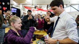 A woman teaches PM Trudeau sign language