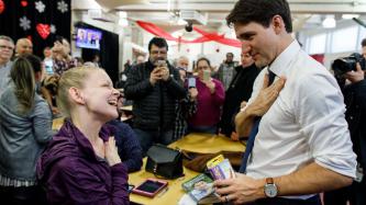 A woman teaches PM Trudeau sign language