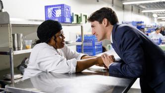 PM Trudeau holds hands with a staff member