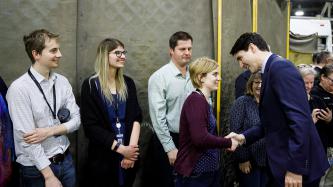 PM Trudeau shakes hands with a woman