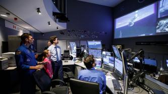 Ella-Grace and PM Trudeau watch video in a control centre 