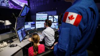PM Trudeau sits at the control centre while Ella-Grace looks on