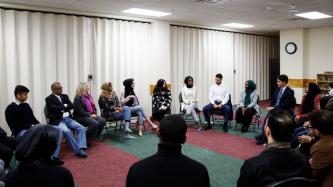 PM Trudeau sits in a circle with a group of people
