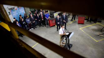 PM Trudeau speaks at the podium while others look on
