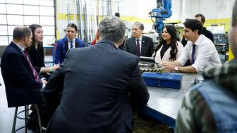 PM Trudeau listens to a woman speak during a roundtable meeting