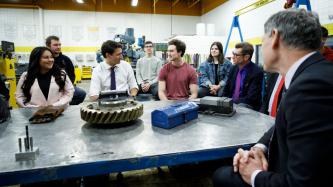 PM Trudeau listens to a man speak during a roundtable meeting